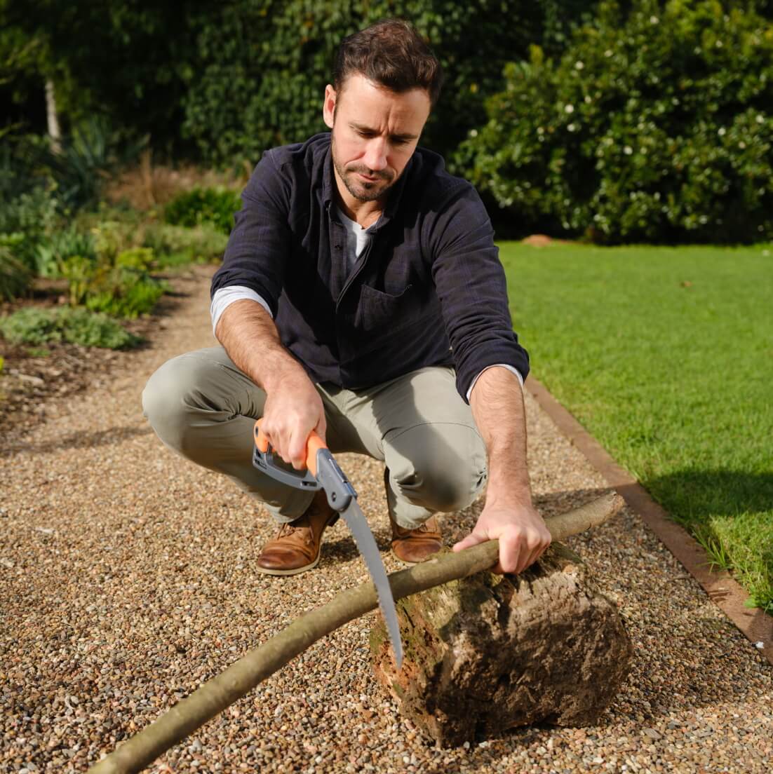 man sawing with hand held pruning saw